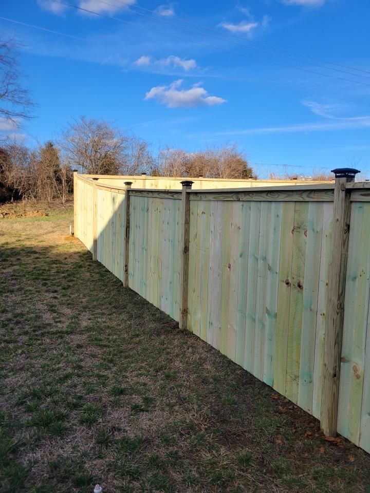 A wooden fence is sitting in the middle of a grassy field.