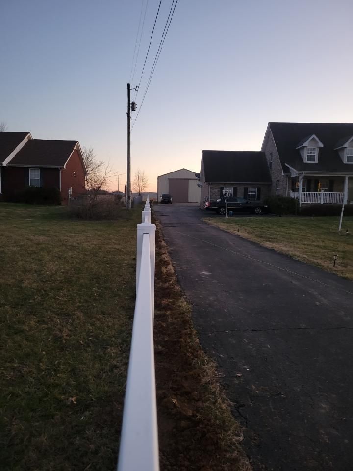 A white fence along the side of a road