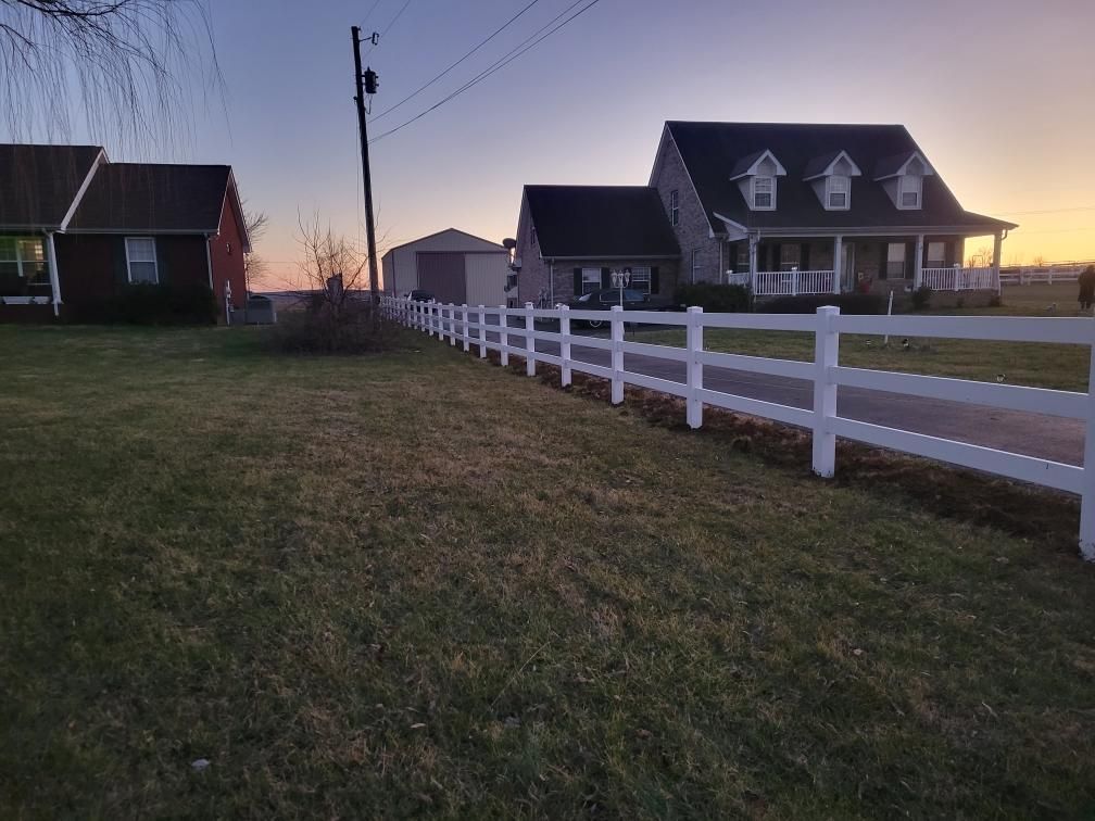 A white fence surrounds a row of houses.