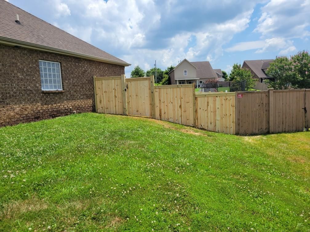 There is a wooden fence in the backyard of a house.
