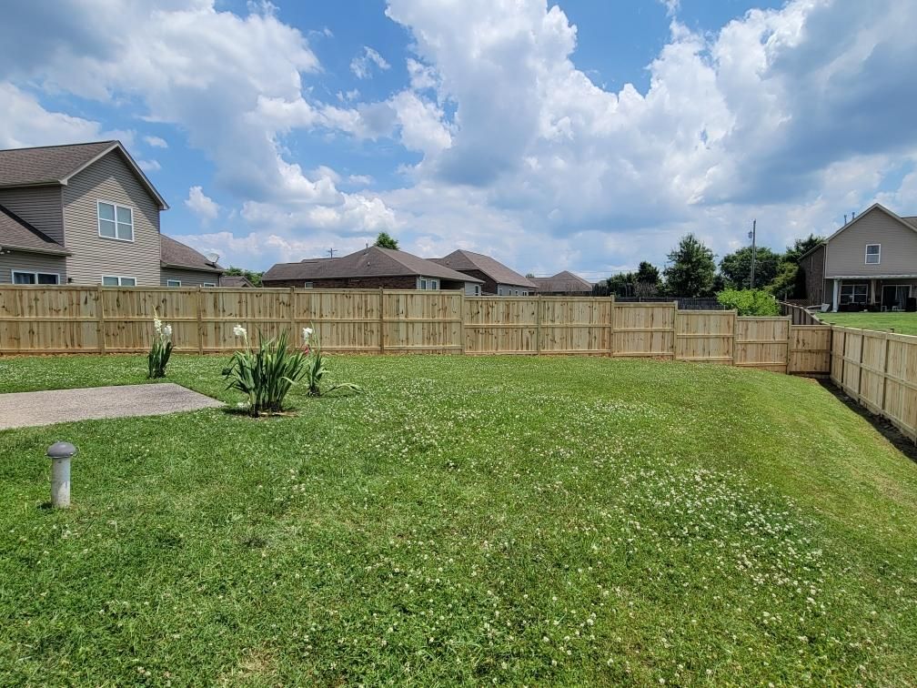 There is a wooden fence in the backyard of a house.