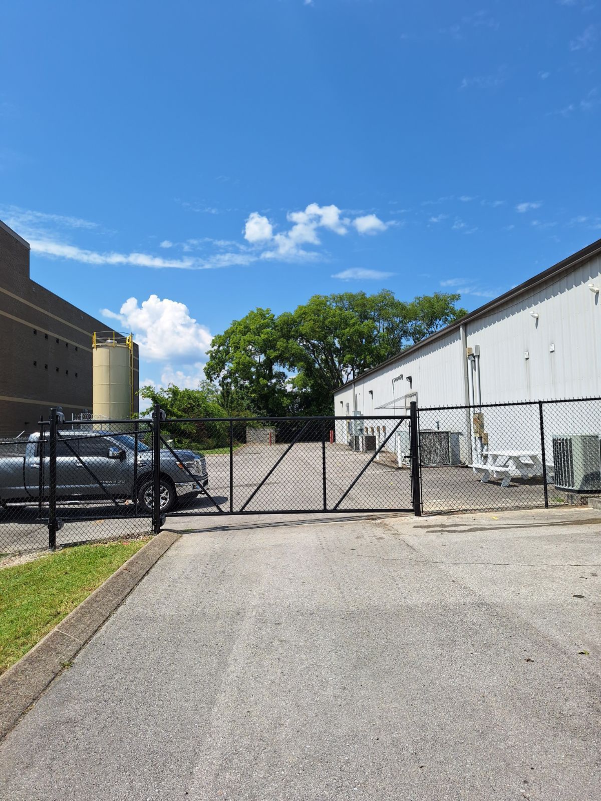 A fenced in parking lot with a truck parked in front of a building.