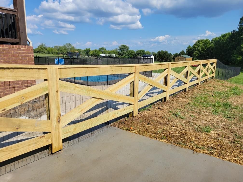 A wooden fence surrounds a swimming pool in a backyard.
