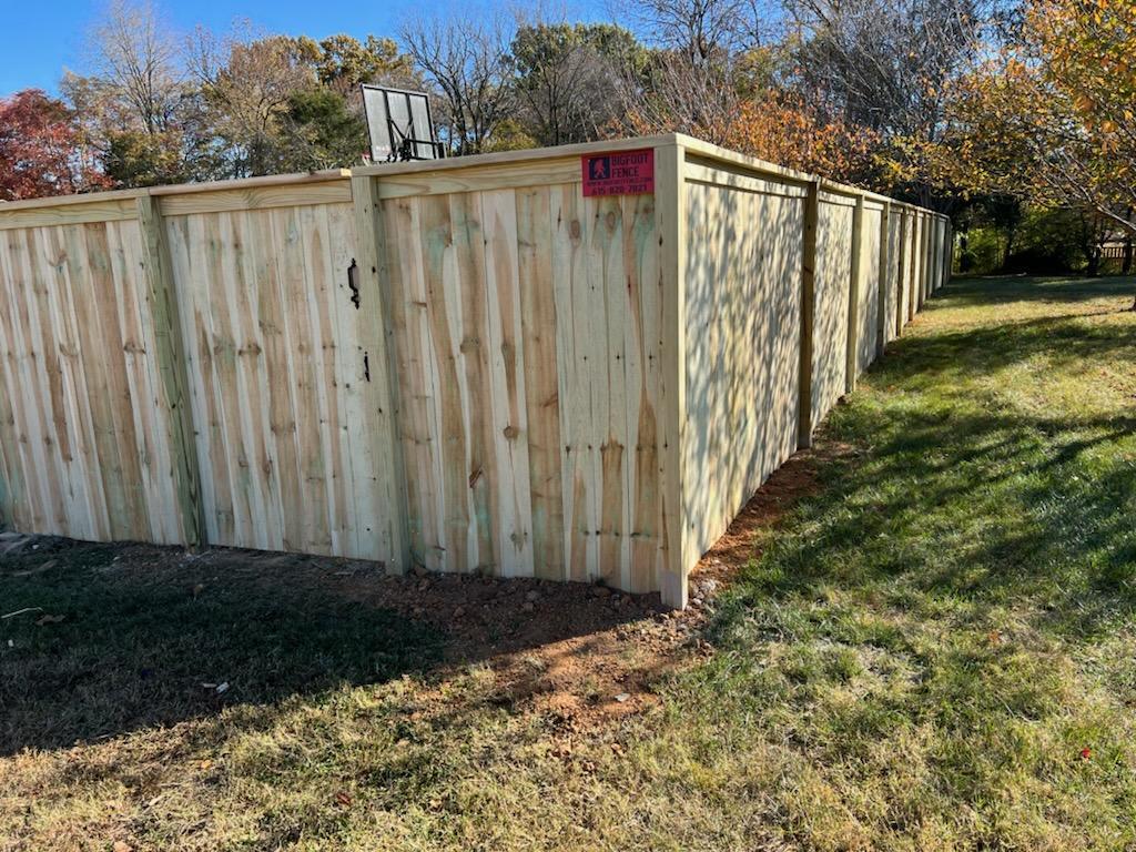 A wooden fence is sitting in the middle of a grassy field.