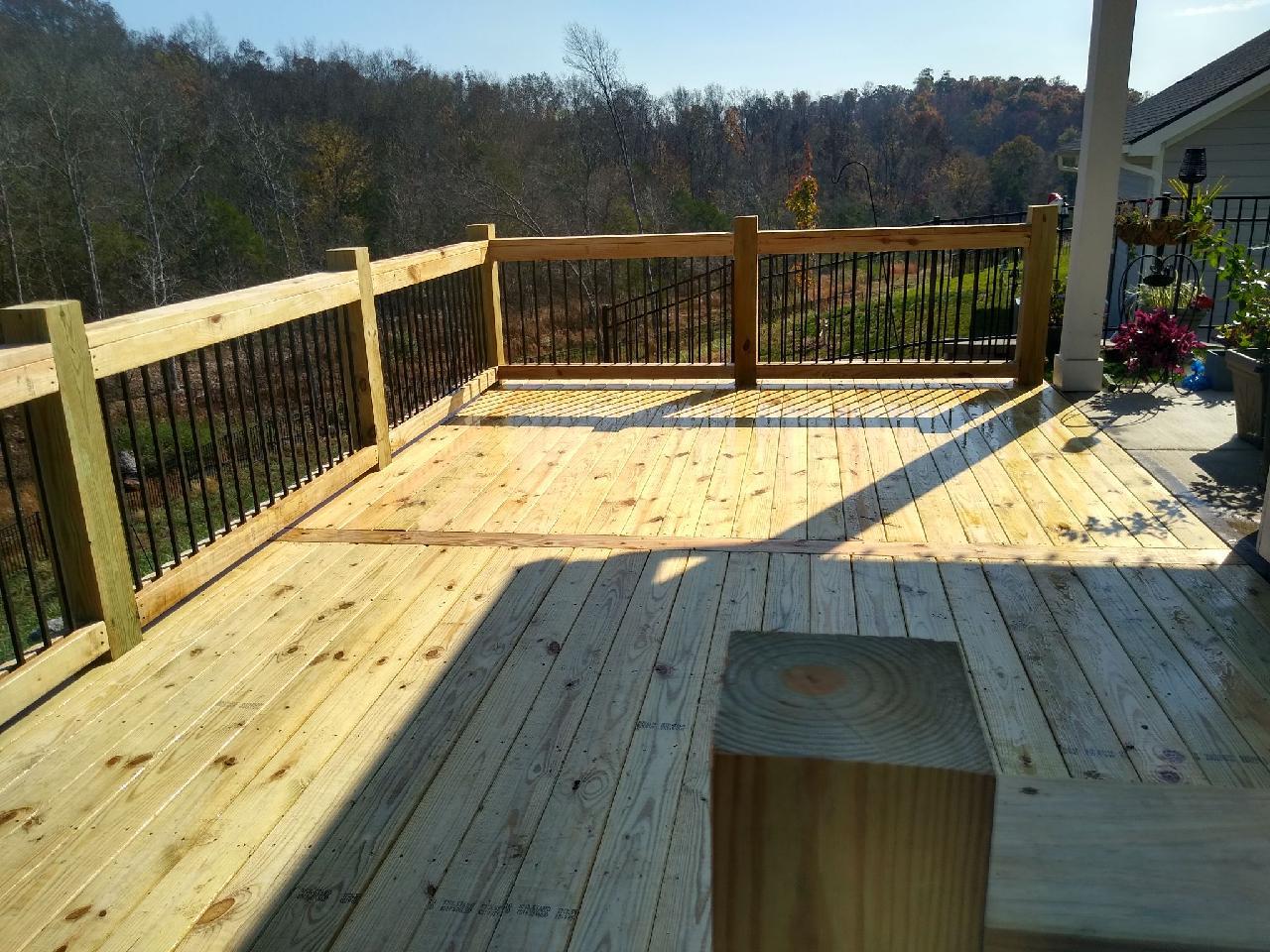 A wooden deck with a railing and a bench