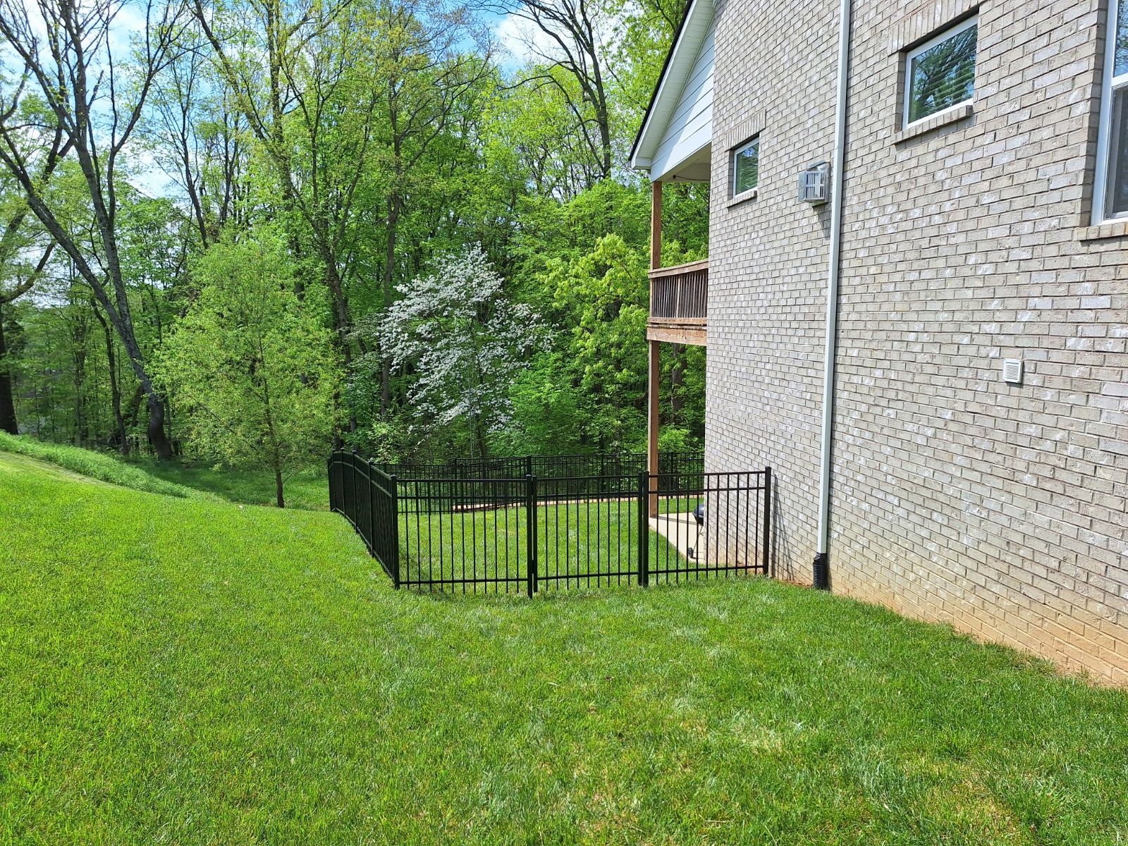 There is a fence in the backyard of a house.