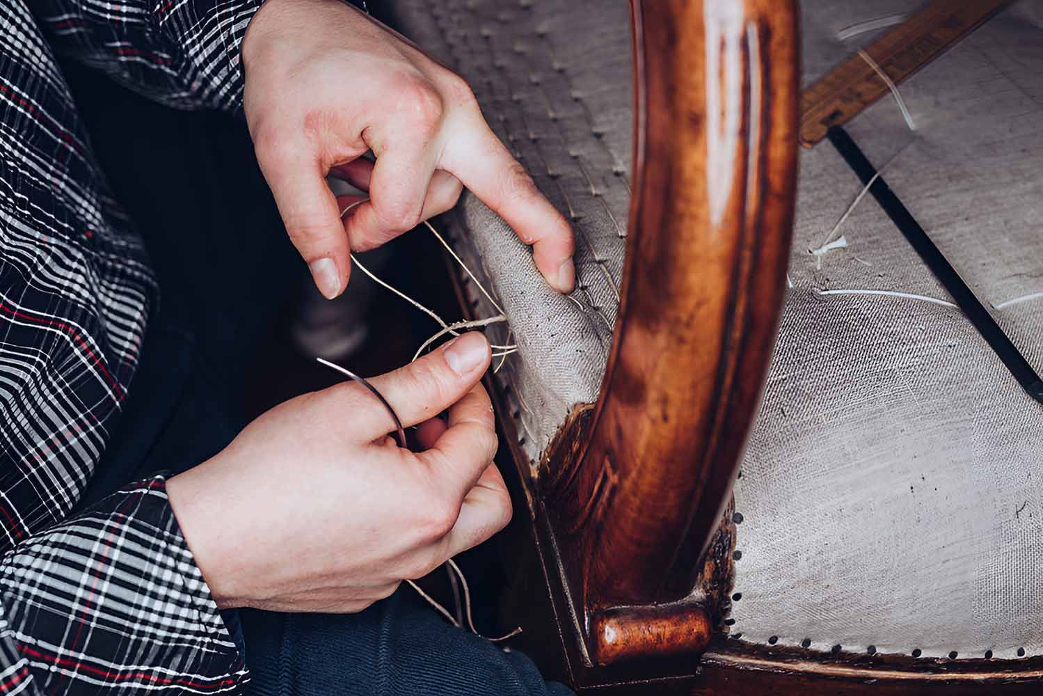 A Person Is Sewing A Chair With A Needle And Thread — Stitch Master in Manunda, QLD