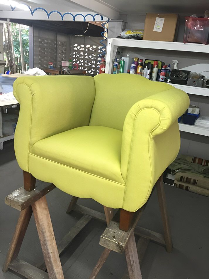 A Yellow Chair Is Sitting On A Wooden Stool In A Room — Stitch Master in Manunda, QLD