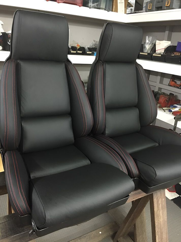 A Pair Of Black Leather Car Seats Are Sitting On Top Of A Wooden Table — Stitch Master in Manunda, QLD