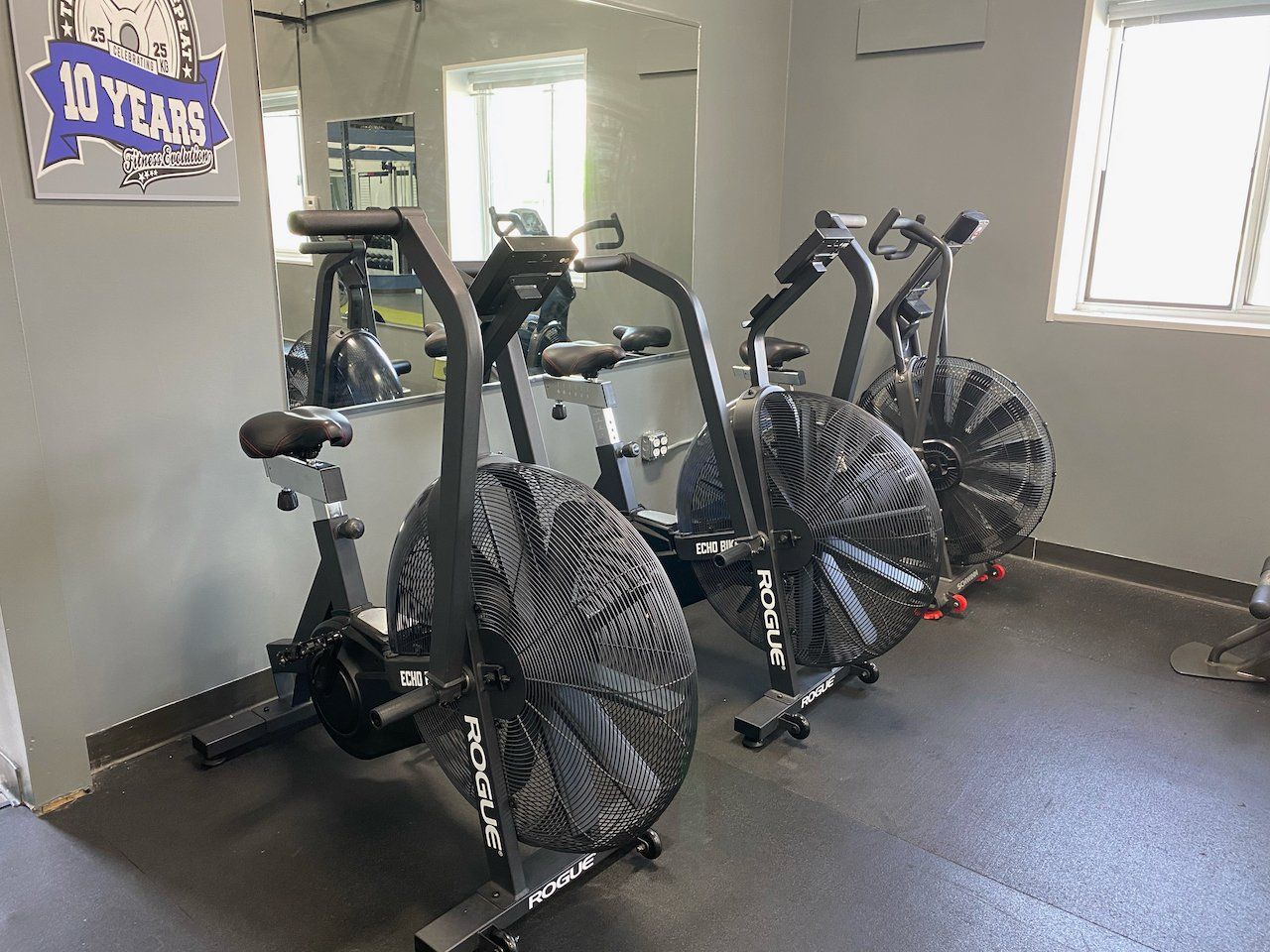 A row of exercise bikes are lined up in a gym.