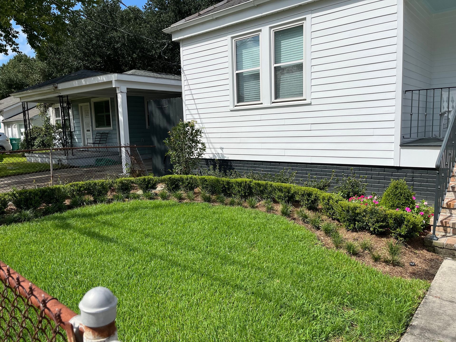 A large white house with a lush green lawn in front of it.