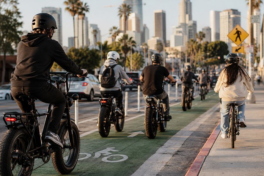 A group of electric bicycle riders in a protected bike lane in Los Angeles, CA, is the focus of the