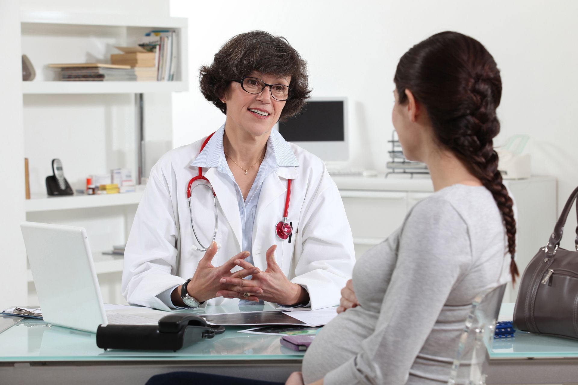 Doctor and pregnant patient in doctors office