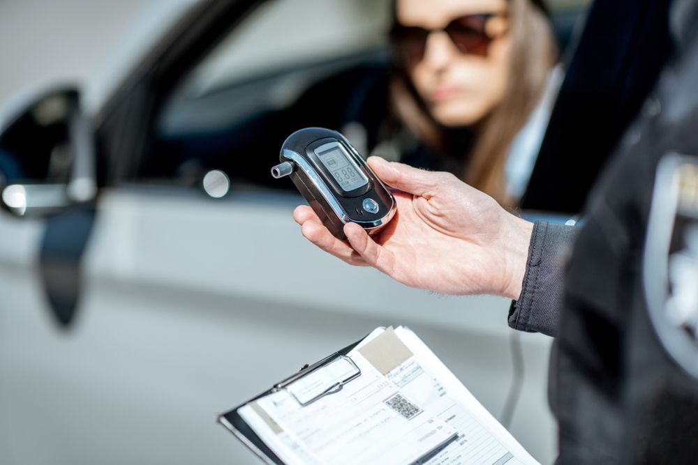 A police officer is reading the results of a breathalyzer just given to a female driver.