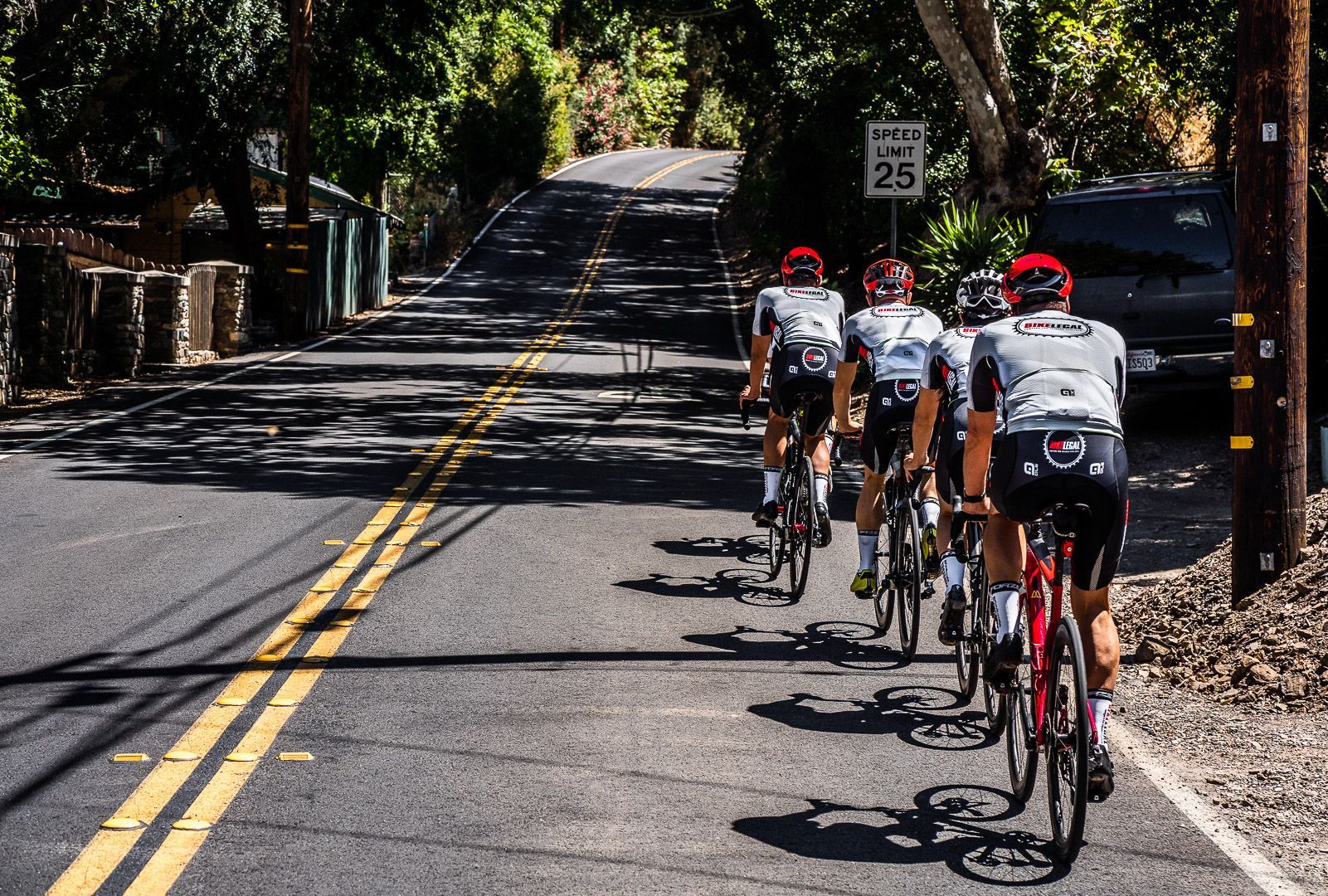 four cyclists on a road without a bicycle lane