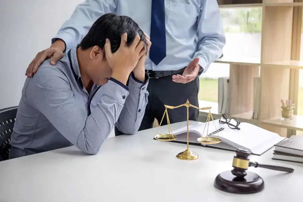attorney consoling client with judge gavel on table
