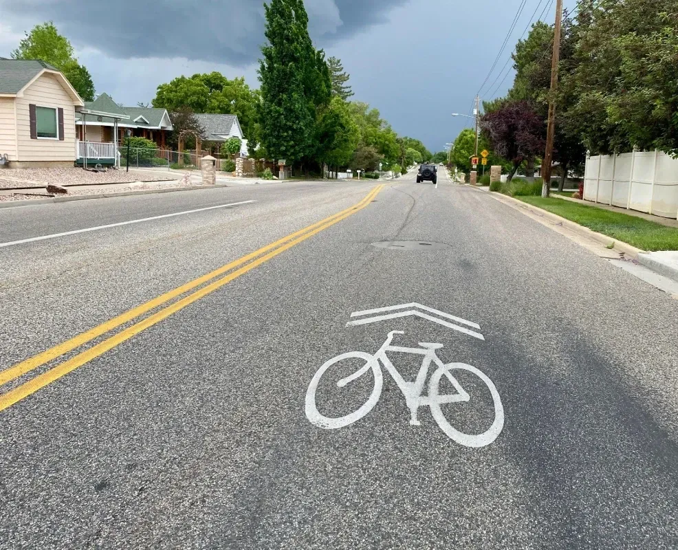 A class III bikeway with a painted sharrow in the center of the road where bicyclists and motorists can share the travel lane.