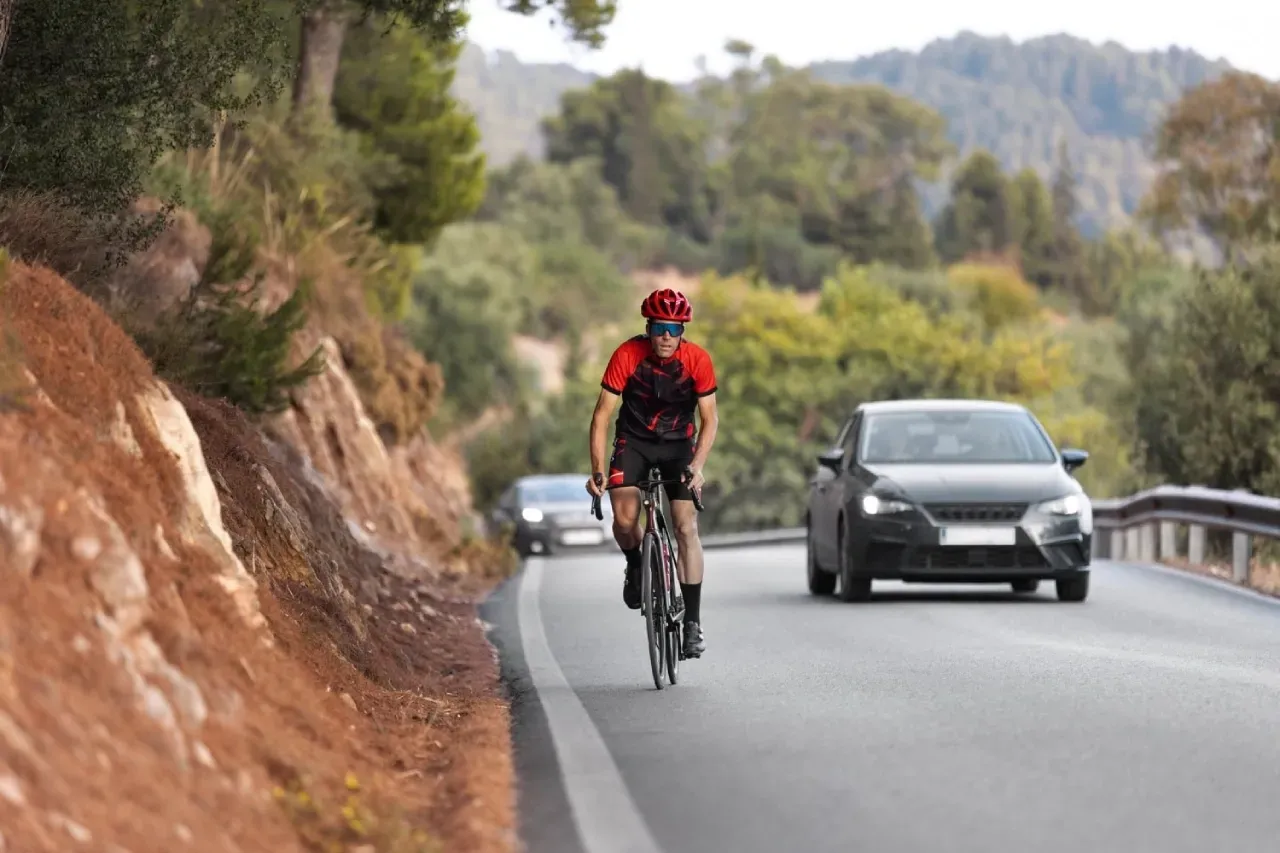 cyclist on a rural road shared with vehicles, no bike lane, no shoulder