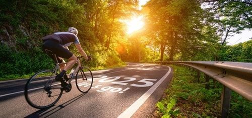 cyclist riding on the road with 2025 Let's Go! Printed on the road. Cycling goals
