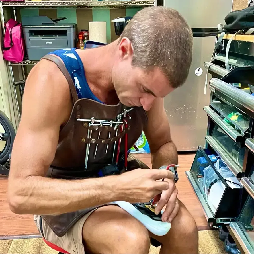 Nate Koch of Long Beach Bike Fit adjusting the cleats on a clients cycling shoes as part of the bike fit process