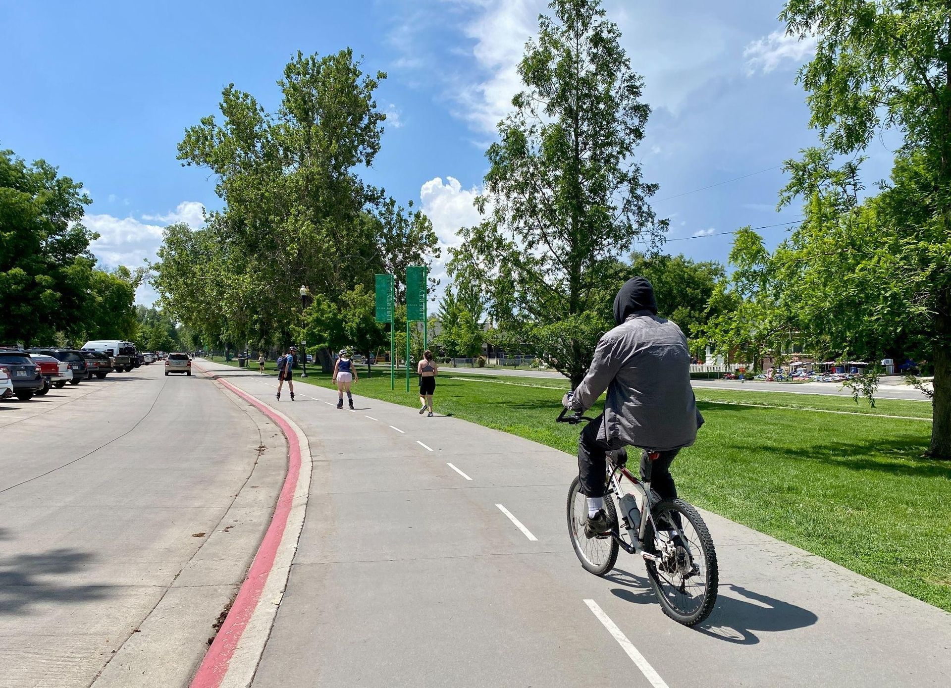 Shared multi-use trail in Salt Lake City with bicycle riders, joggers, and skaters