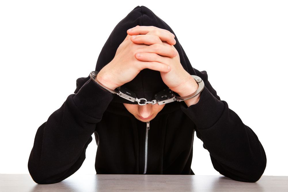 teen in custody in handcuffs