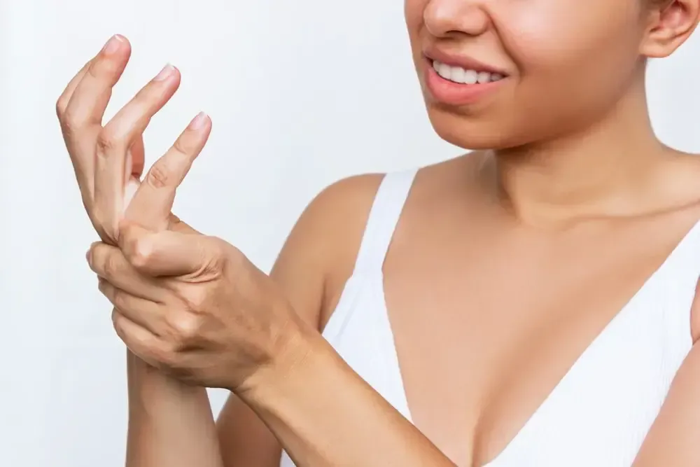 young woman holding painful hand