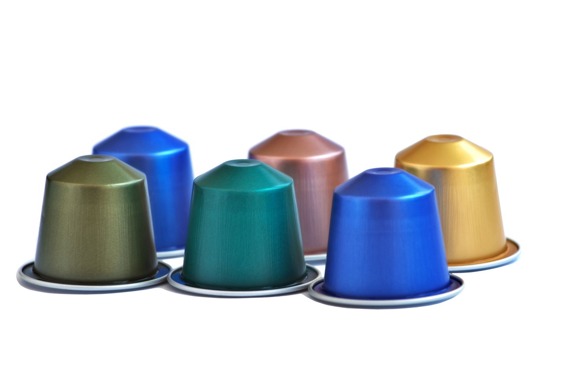 Sei cialde di caffè colorate disposte su una superficie bianca; le tonalità includono verde, blu e oro.