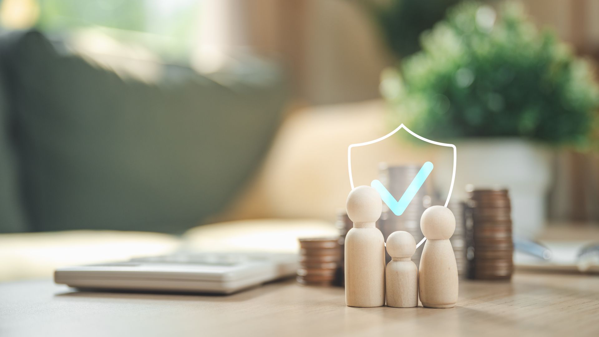 Small wooden figures beside coin stacks with a checkmark shield on a desk, symbolizing security or insurance