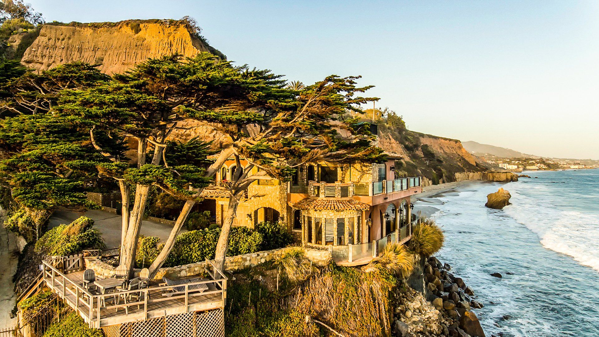 A house is sitting on top of a cliff overlooking the ocean.