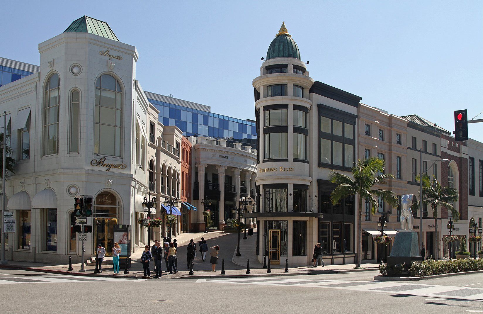 A group of people are walking in front of a building with a dome on top