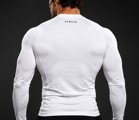 Man wearing a fitted white long-sleeve athletic shirt against a dark background