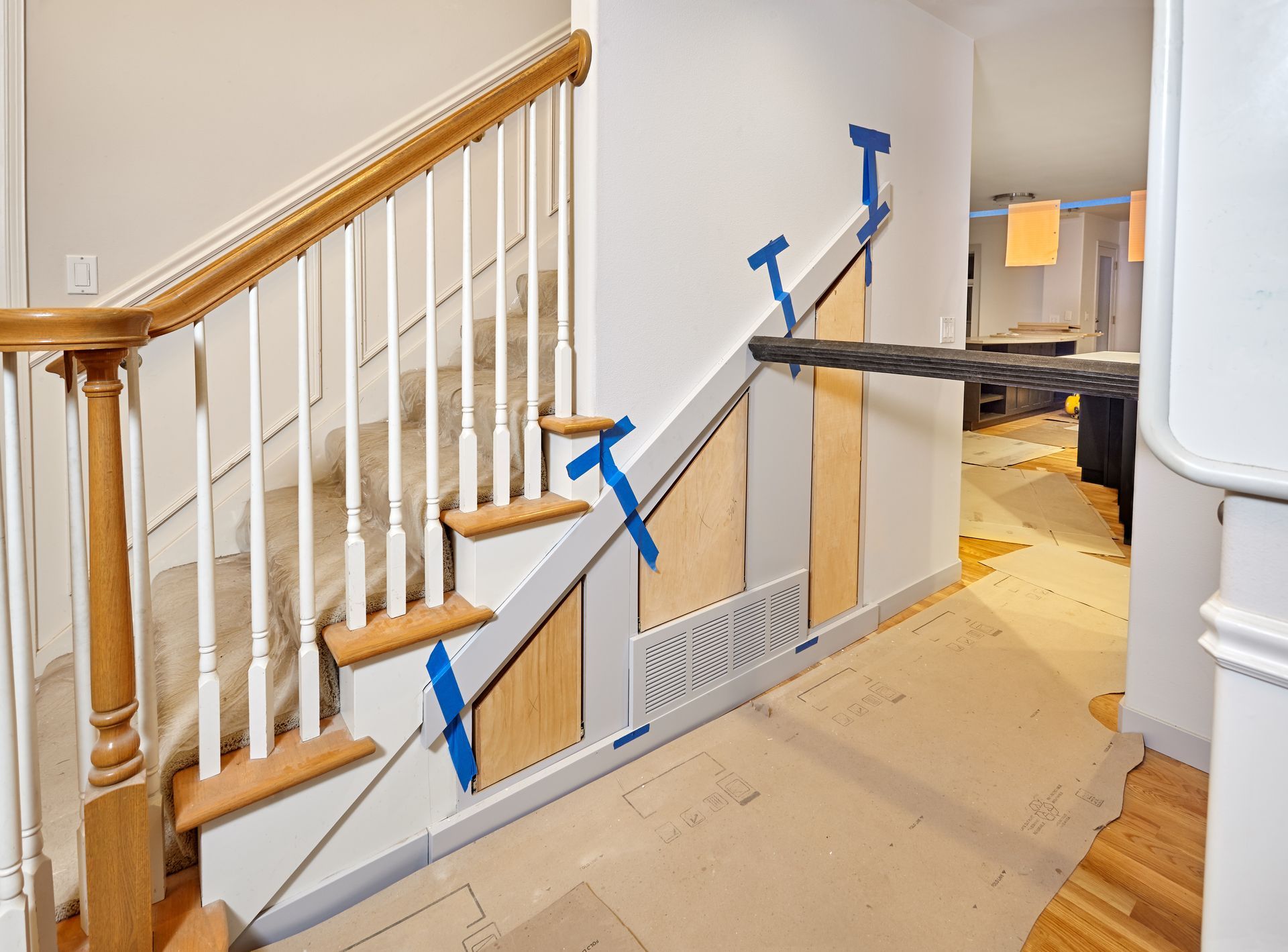 Stairway with blue handrail supports and a black plank setup blocking the landing corridor