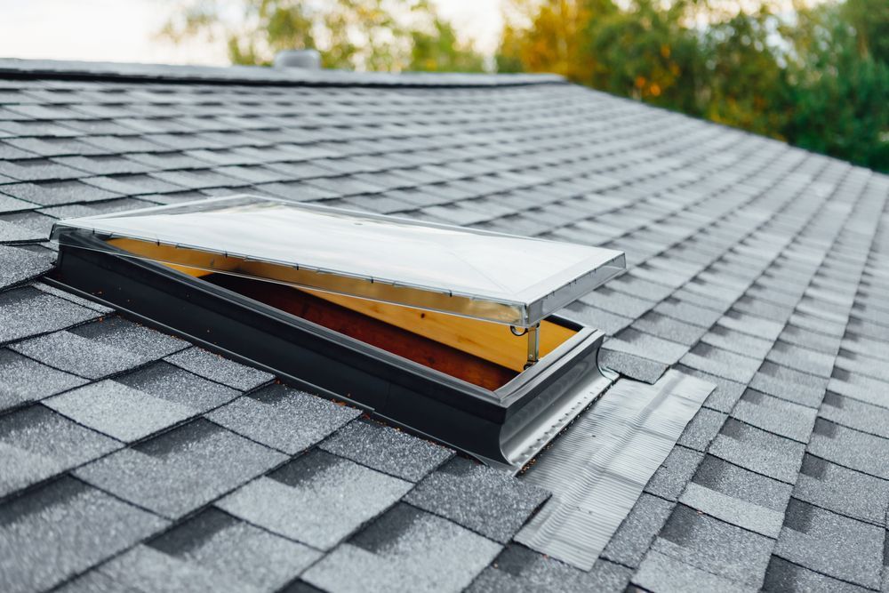 Open skylight on a gray asphalt shingle roof.