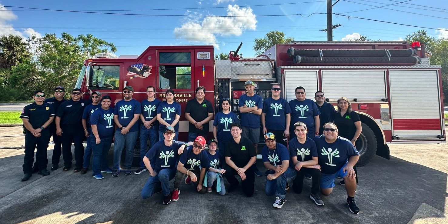 A group of firefighters are posing for a picture in front of a fire truck.