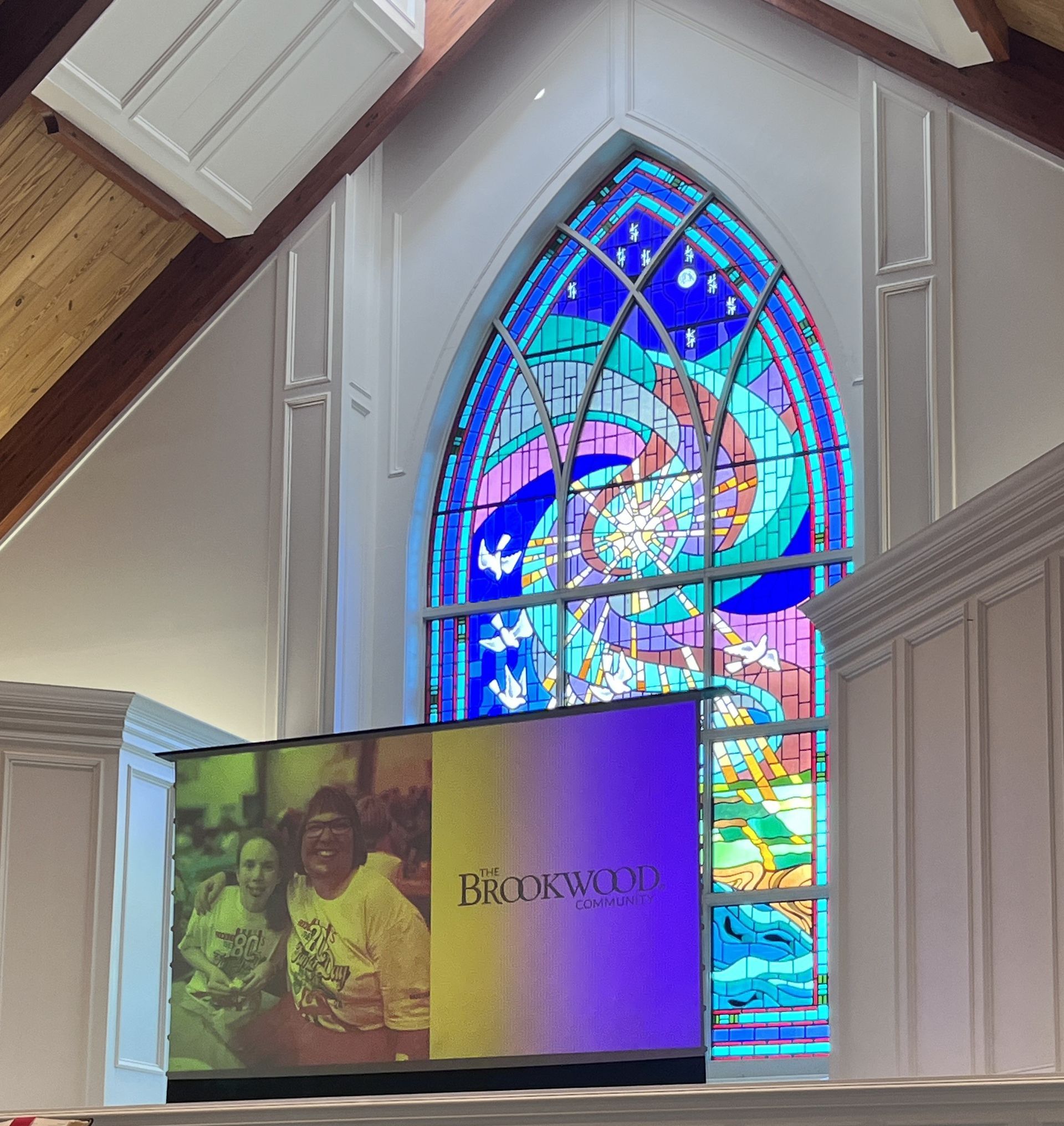 A church with a stained glass window and a sign that says brookwood