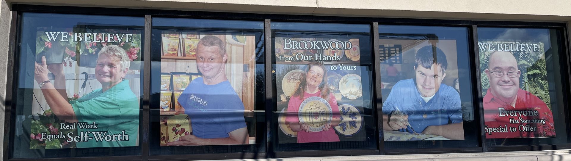 A group of people are standing in front of a window.