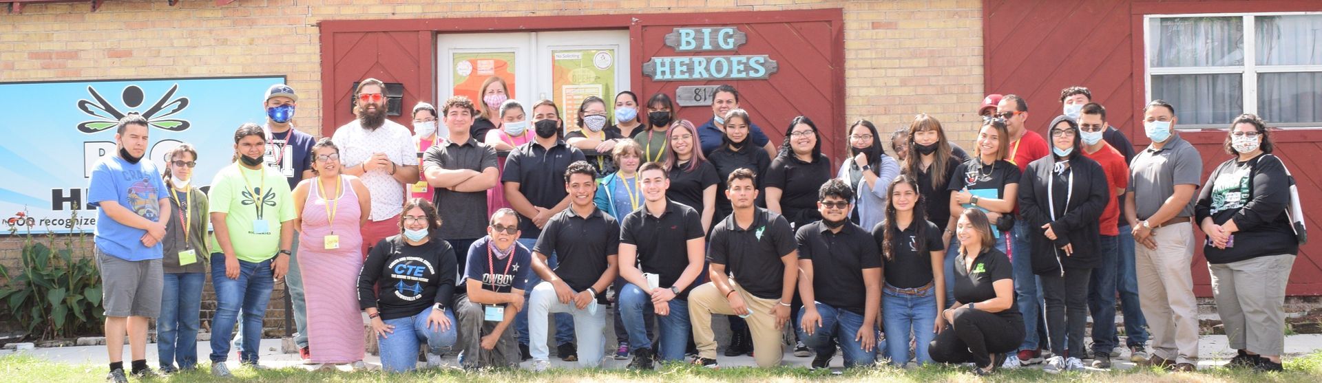 Group of people posing in front of a building with 