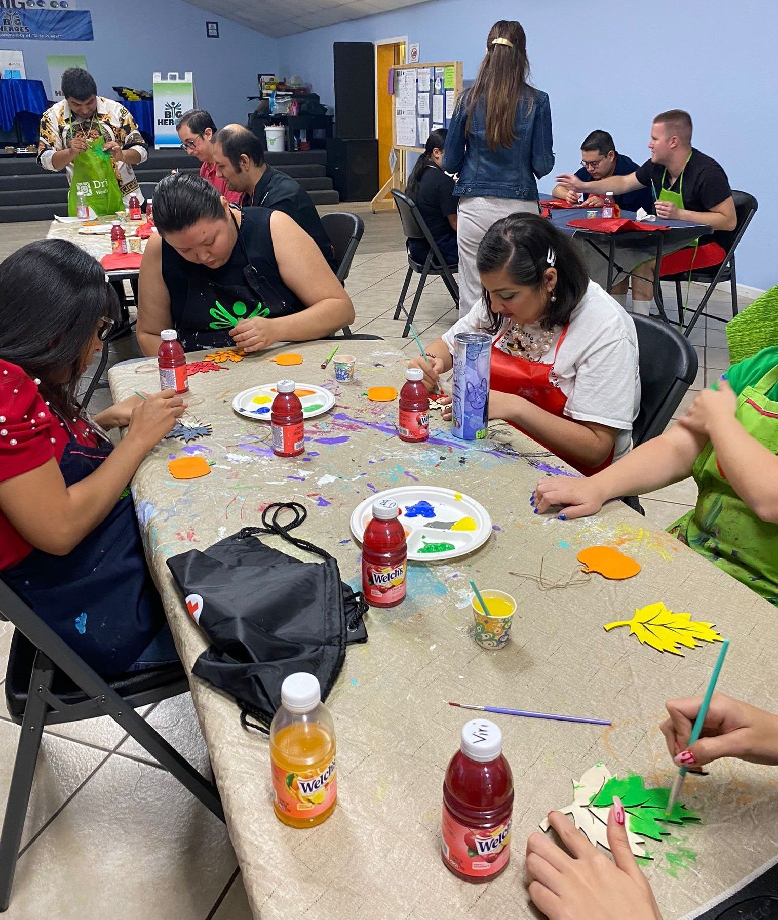 A group of people are sitting around a table painting.