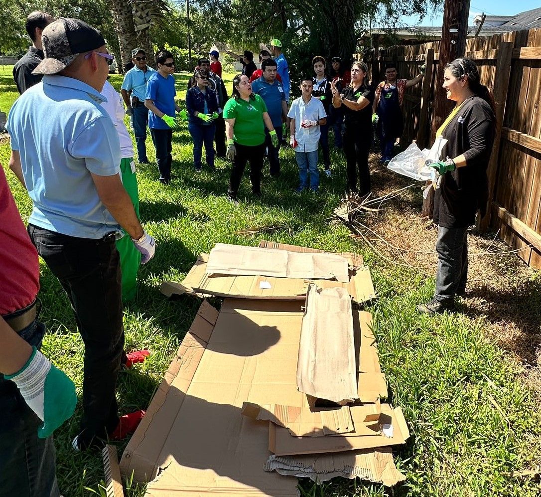 A group of people are standing around a pile of cardboard boxes.