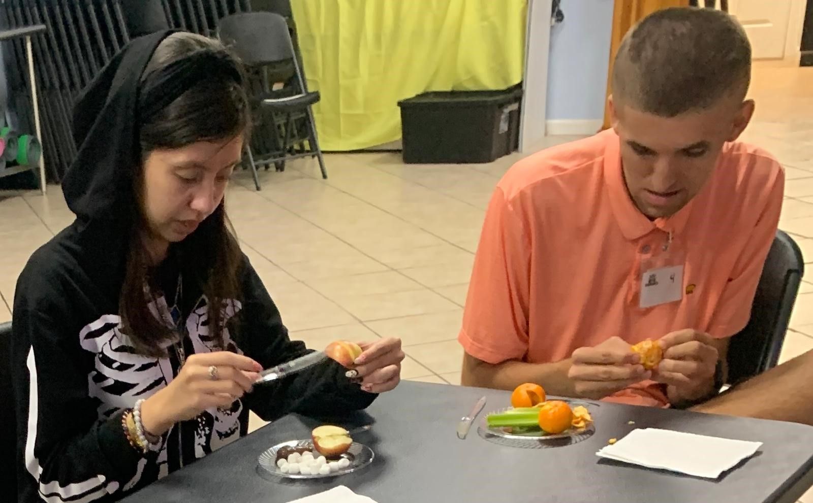 A man and a woman are sitting at a table eating food.