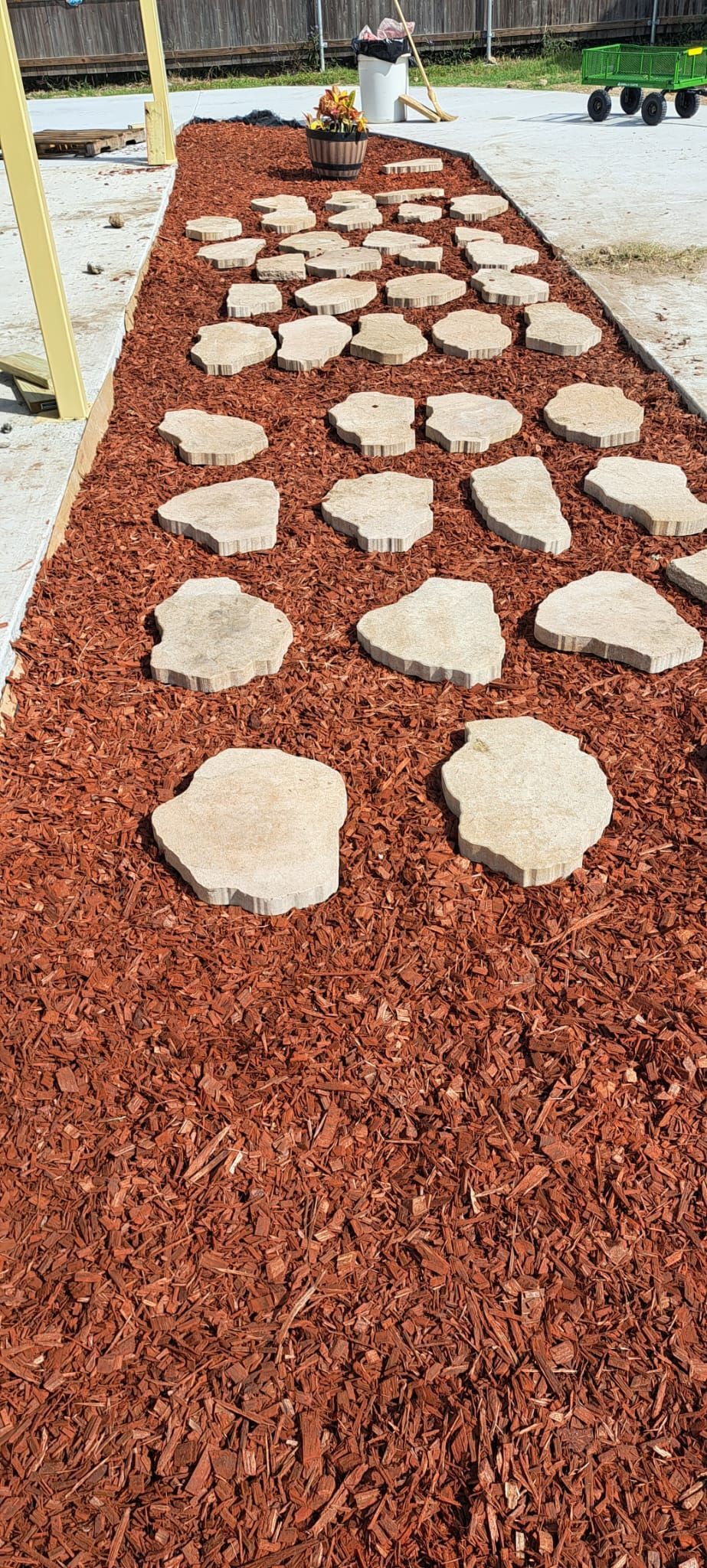 A walkway made of rocks and mulch in a garden.