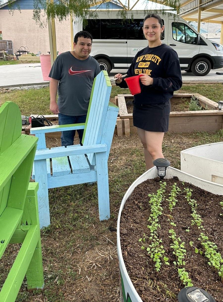 A man and a woman are standing next to each other in a garden.