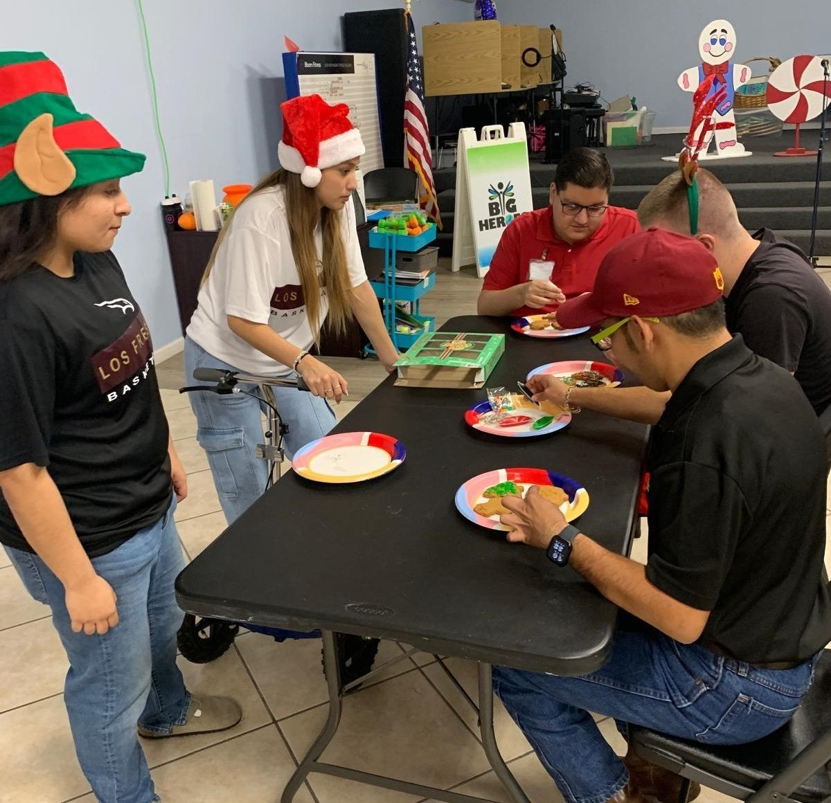 A group of people are sitting around a table with plates of food