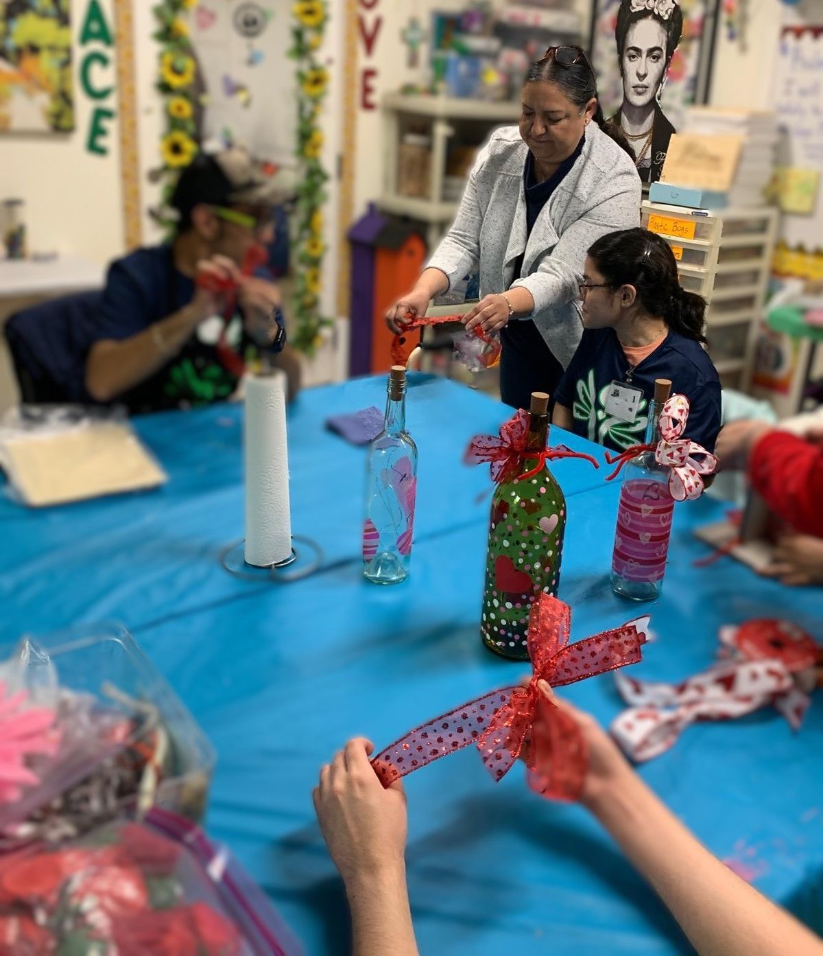 A group of people are sitting around a table with bottles and ribbons on it