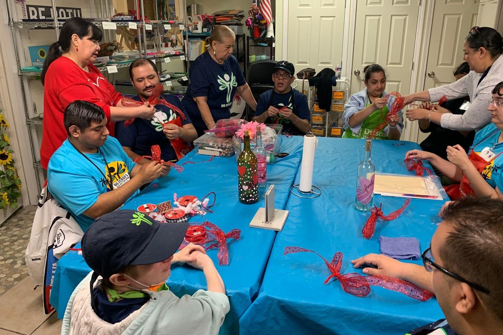 A group of people are sitting around a table making crafts.