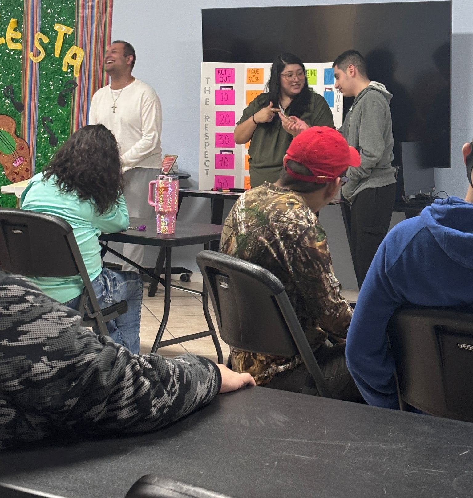 A group of people in a room with a sign that says festa