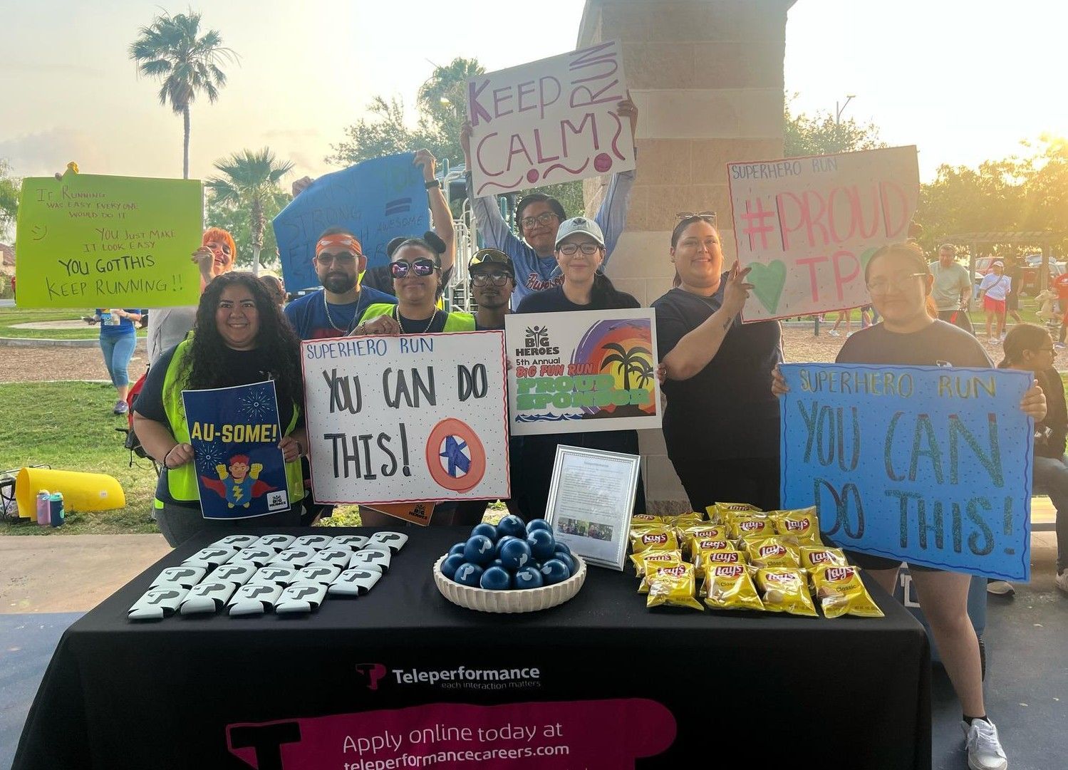 A group of people are standing around a table holding signs.