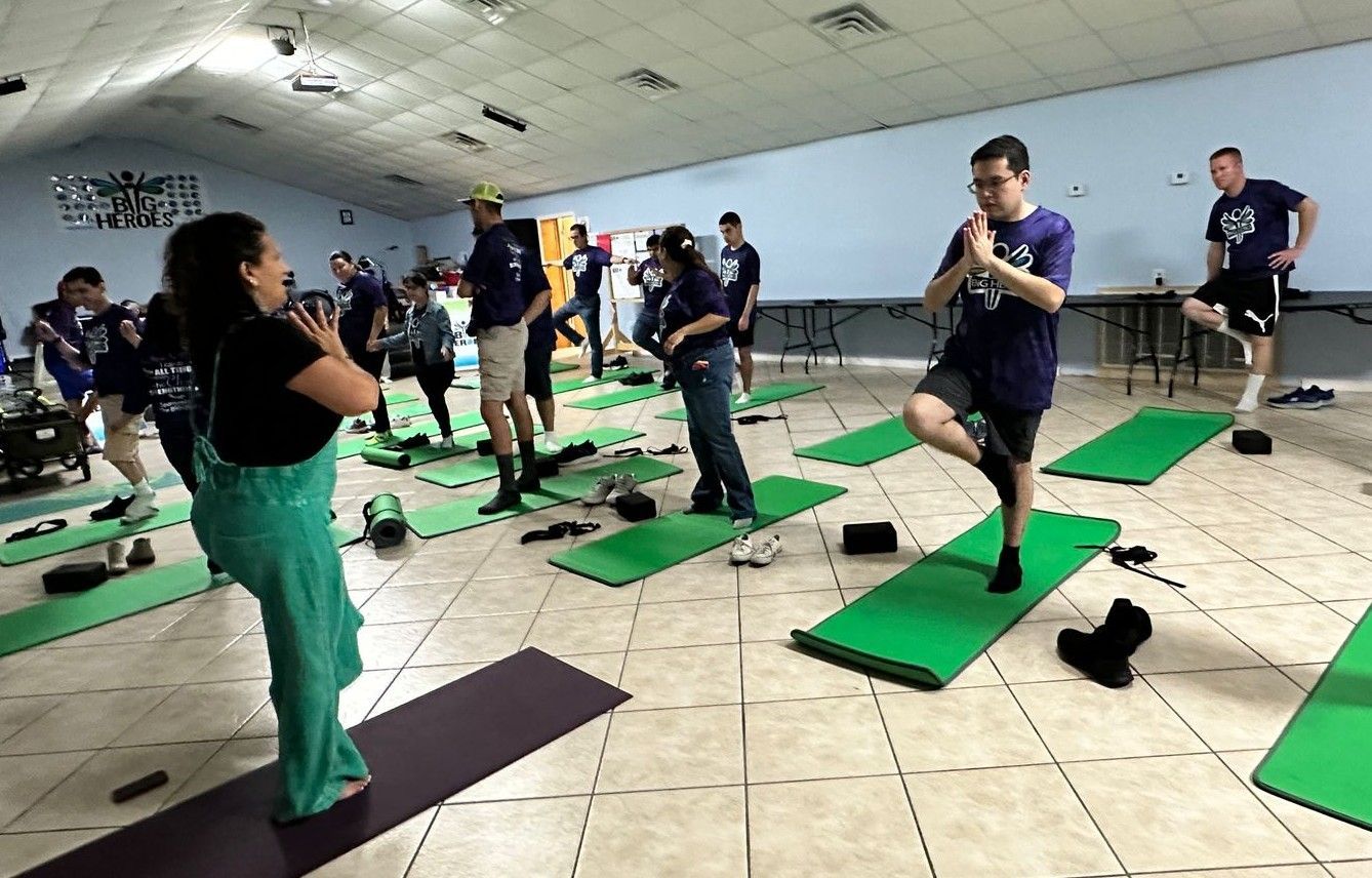A group of people are doing yoga in a room