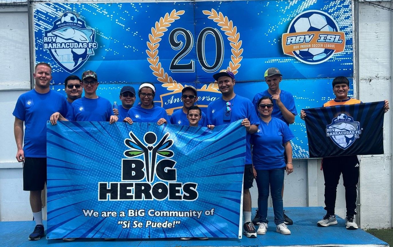 A group of people standing in front of a big heroes banner